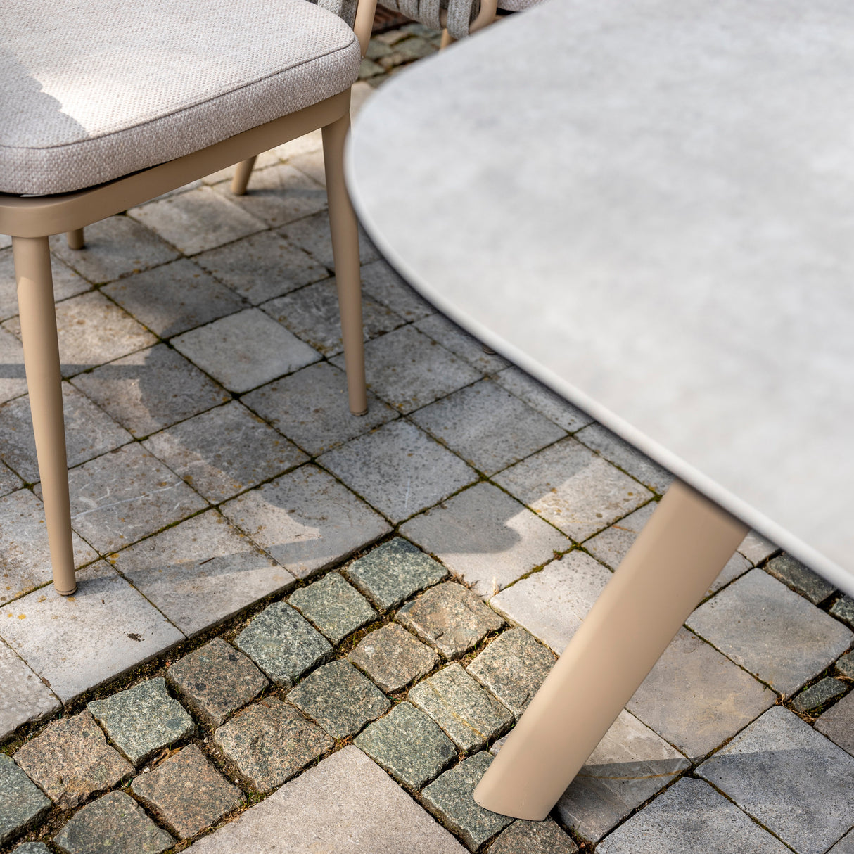 Four Seasons Outdoor Eva 6-seat metal dining set with Manolo 180cm ceramic barrel table and matching dining chairs.