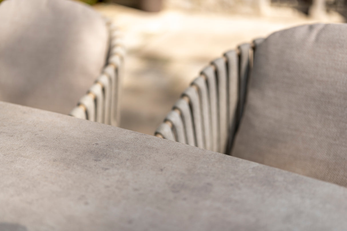 4 Seasons Outdoor Eva 6-seat metal dining set with Manolo 180cm ceramic barrel table and matching dining chairs.