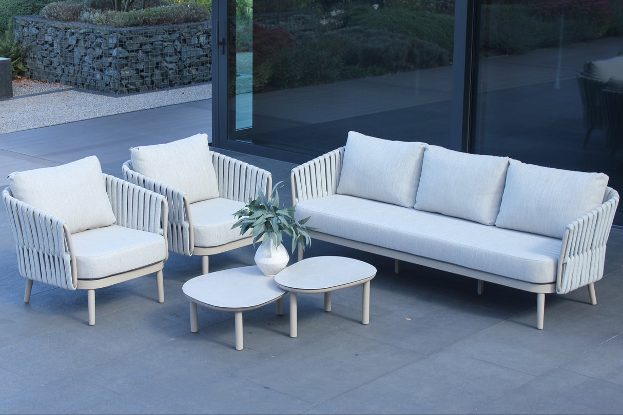 4 Seasons Outdoor Eva lounge set with two Monroe coffee tables and a gentle support table, featuring metal frames and plush cushions.