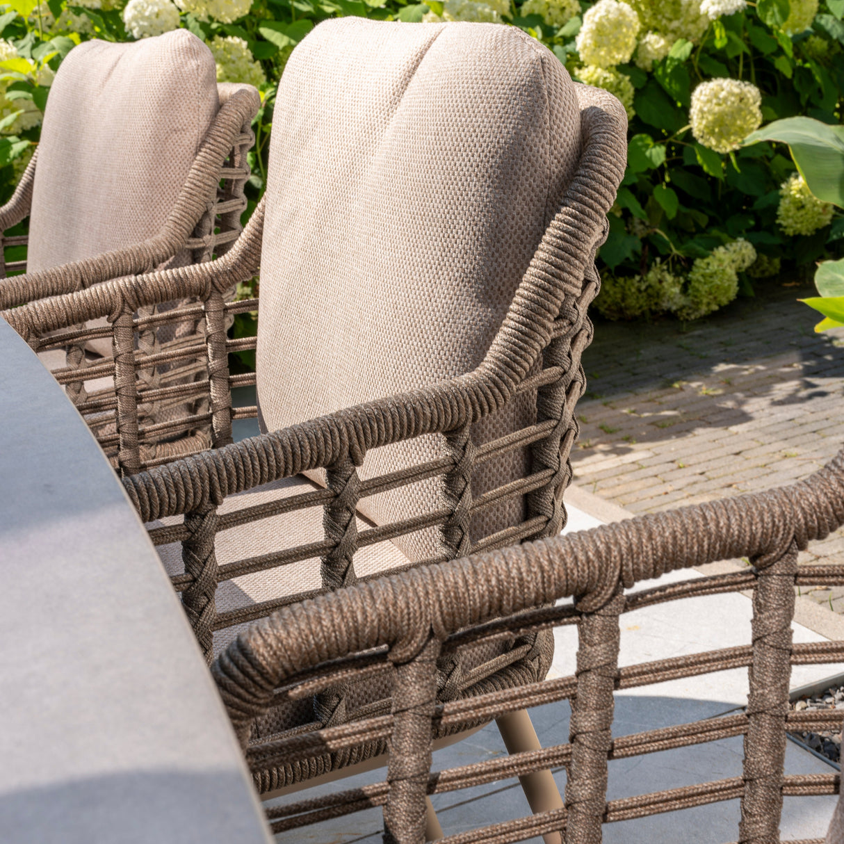 4 Seasons Outdoor Puglia 6-seat round metal dining set with Donato Latte table and matching chairs, outdoor furniture for patio dining.