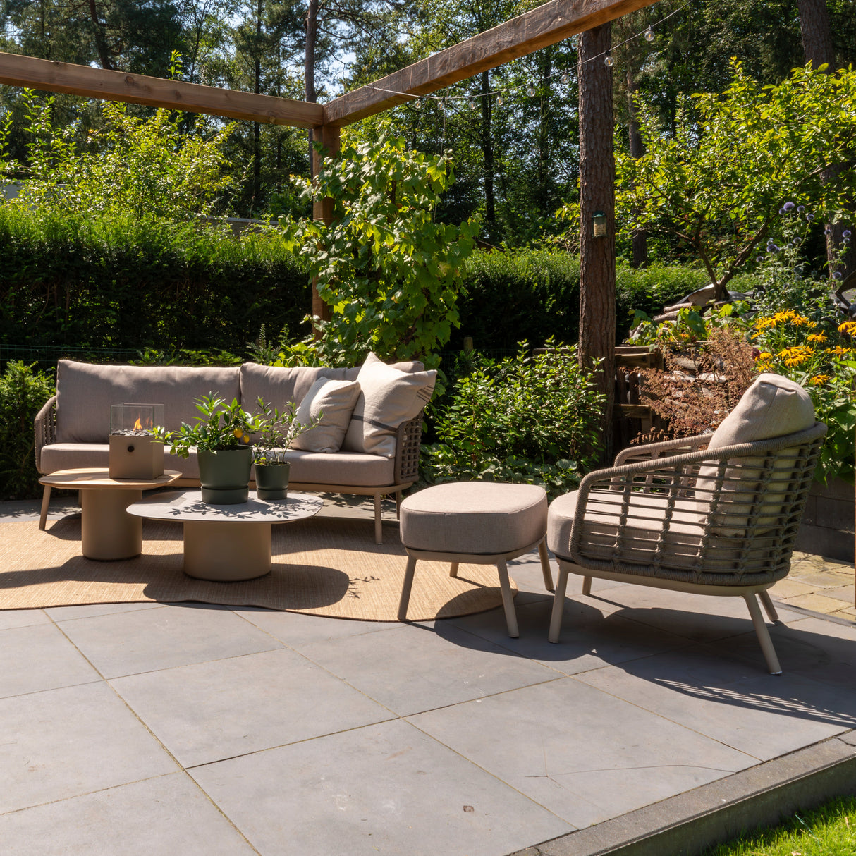 4 Seasons Outdoor Puglia Lounge LUX Set in Latte with 3-seater sofa, chairs, footstool, and tables in an outdoor setting.