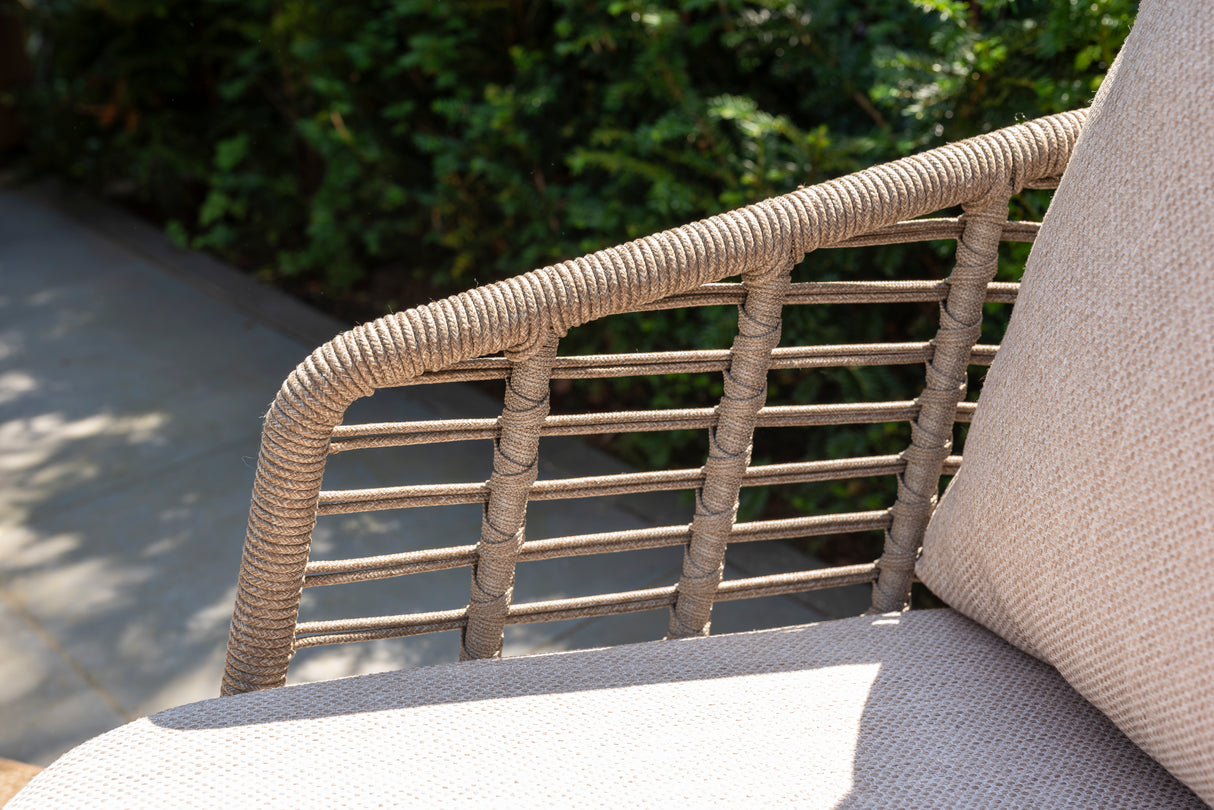 4 Seasons Outdoor Puglia Lounge LUX Set in Latte featuring a 3-seater sofa, chairs, footstool, and tables in a cozy outdoor setting.