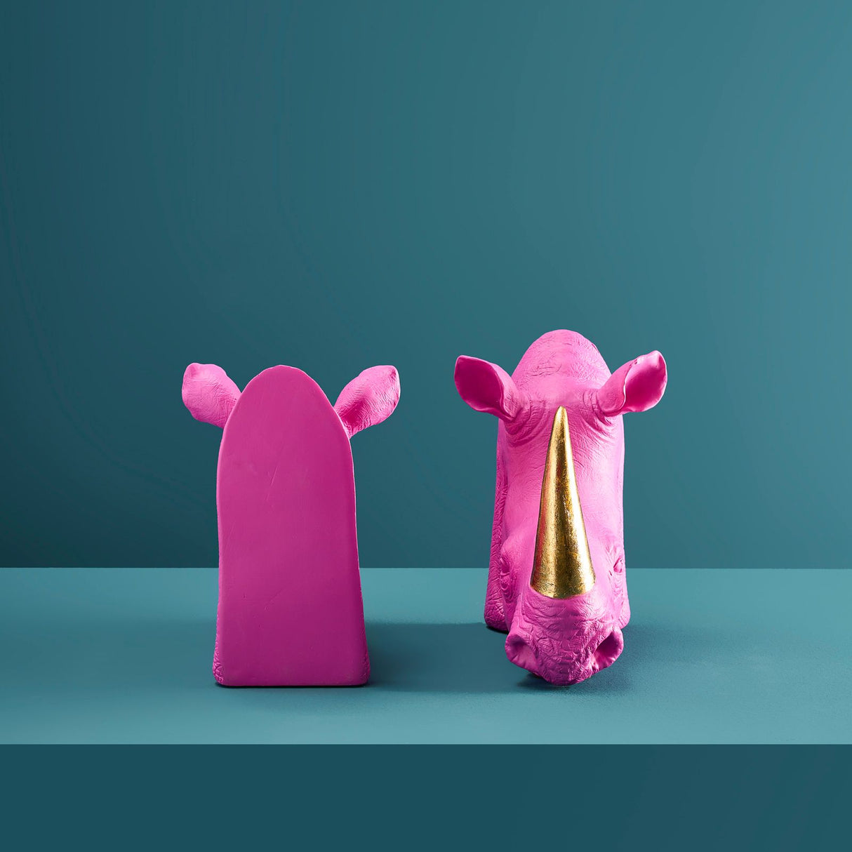 Pair of magenta and gold rhinoceros-shaped bookends by Werner Vob, decorative indoor ornaments for home bookshelves.