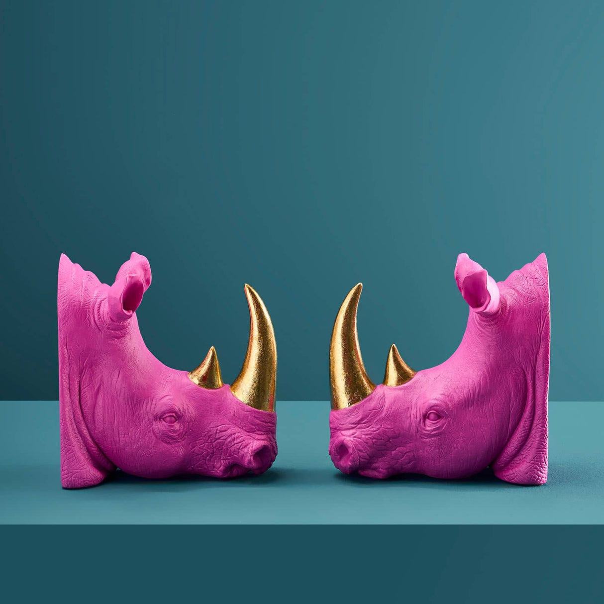 Set of two WERNS Rhinoceros bookends in magenta and gold, decorative indoor ornaments for home shelving or desks.