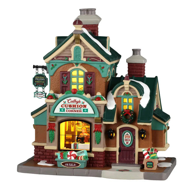 Lemax Cathy’s Cushion Corner illuminated building from the Christmas Village collection, featuring festive holiday decoration and detailed design.