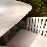 4 Seasons Outdoor Eva 6-seat metal dining set with Manolo 180cm ceramic barrel table and matching chairs, stylish outdoor furniture.