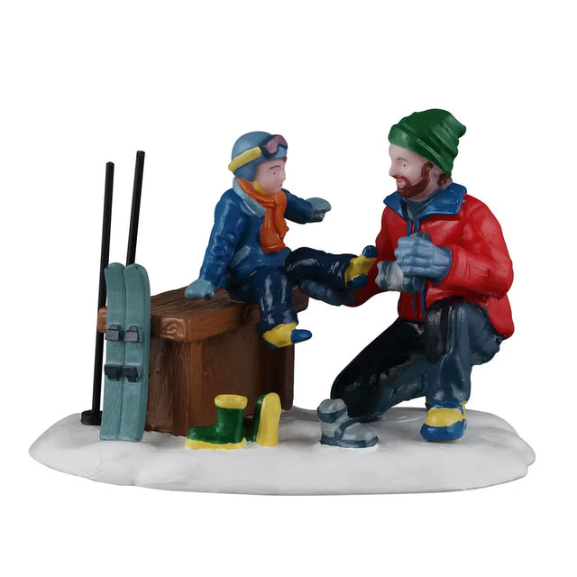 Lemax Father and Son Ski Day Christmas Village figurine featuring a father and son with skis and winter clothing.