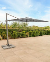 Kettler Luna 3x3M square cantilever parasol with slate canopy, granite base, and night cover in a stylish outdoor setting.
