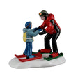 Lemax Ski Slope Lesson Christmas Village figurine showing children learning to ski on a snowy slope in a festive village scene.
