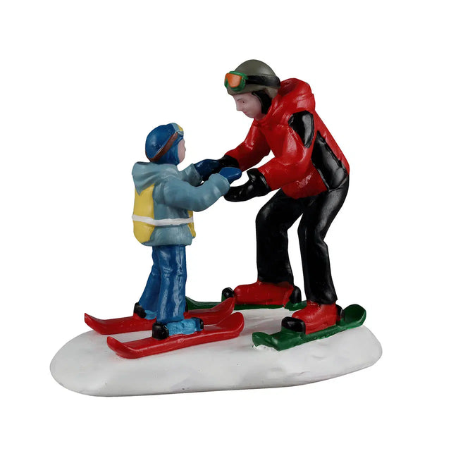 Lemax Ski Slope Lesson Christmas Village figurine showing children learning to ski on a snowy slope in a festive village scene.
