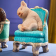 Werner Voß Snoozing Piglet ornament on green armchair, a 20cm luxury German designer figurine for home decor.